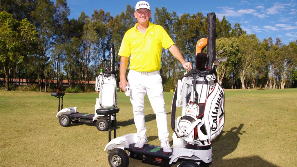 golf cart by Golf skate caddy features a man and the cart on a golf course with trees in the background