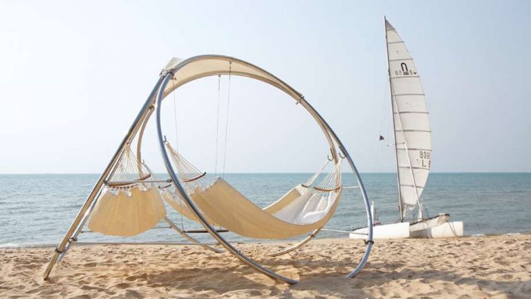 hammocks by trinity hammocks on a beach with a sailboat in the background
