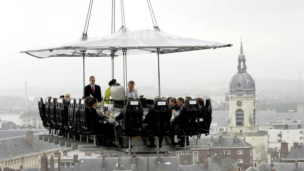 outdoor dining by dinner in the sky people hanging from a crane having dinner