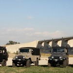 utility vehicles by icon utility vehicles vehicles in front of a river with a bridge in the background