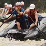 adventures features women rafting down rapids on a river