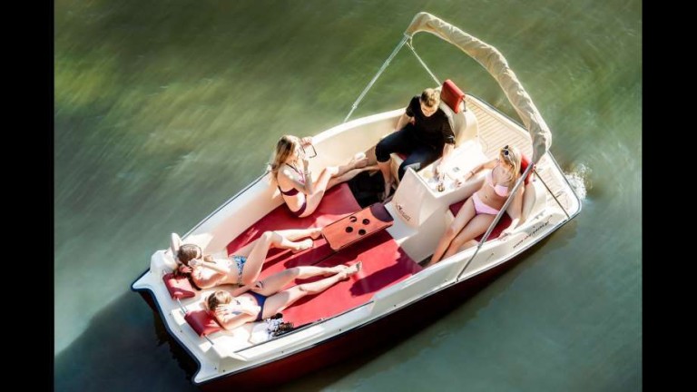 boat by JoyBoat Sky Yacht floating on a body of water with a family
