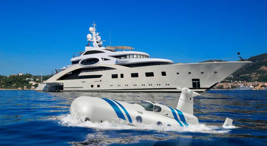 luxury submarines in the ocean next to a yacht in the ocean