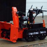 snowblower by robotshop orange and black in the driveway