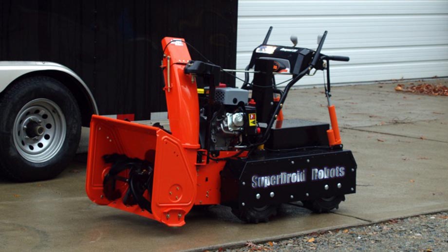 snowblower by robotshop orange and black in the driveway