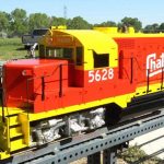 luxury train by Backyard Trains features an orange and yellow train on a backyard tracks