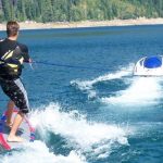luxury water toy by solo ski machine features man skiing behind the solo on a body of water