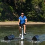 luxury water bike by schiller bikes with someone riding on a lake with a beach